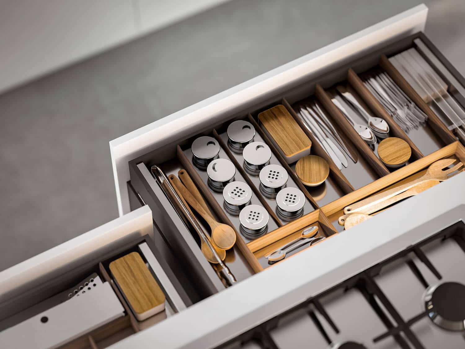 Accessorized drawer with inserts in Oak wood and stainless steel.