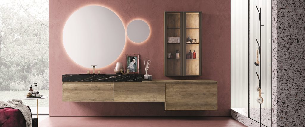 Modern bathroom with a wooden vanity, a large mirror, and a pink wall.