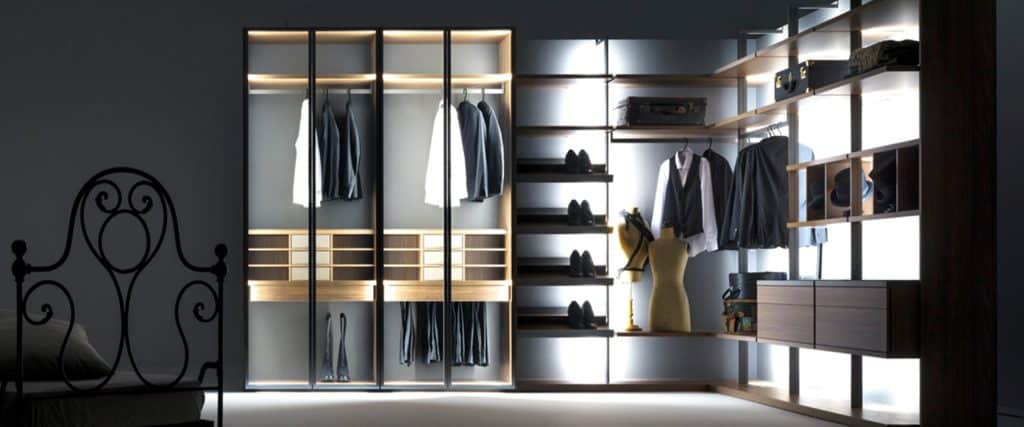 Modern walk-in closet with glass doors, wooden shelves, and a clothing rack.