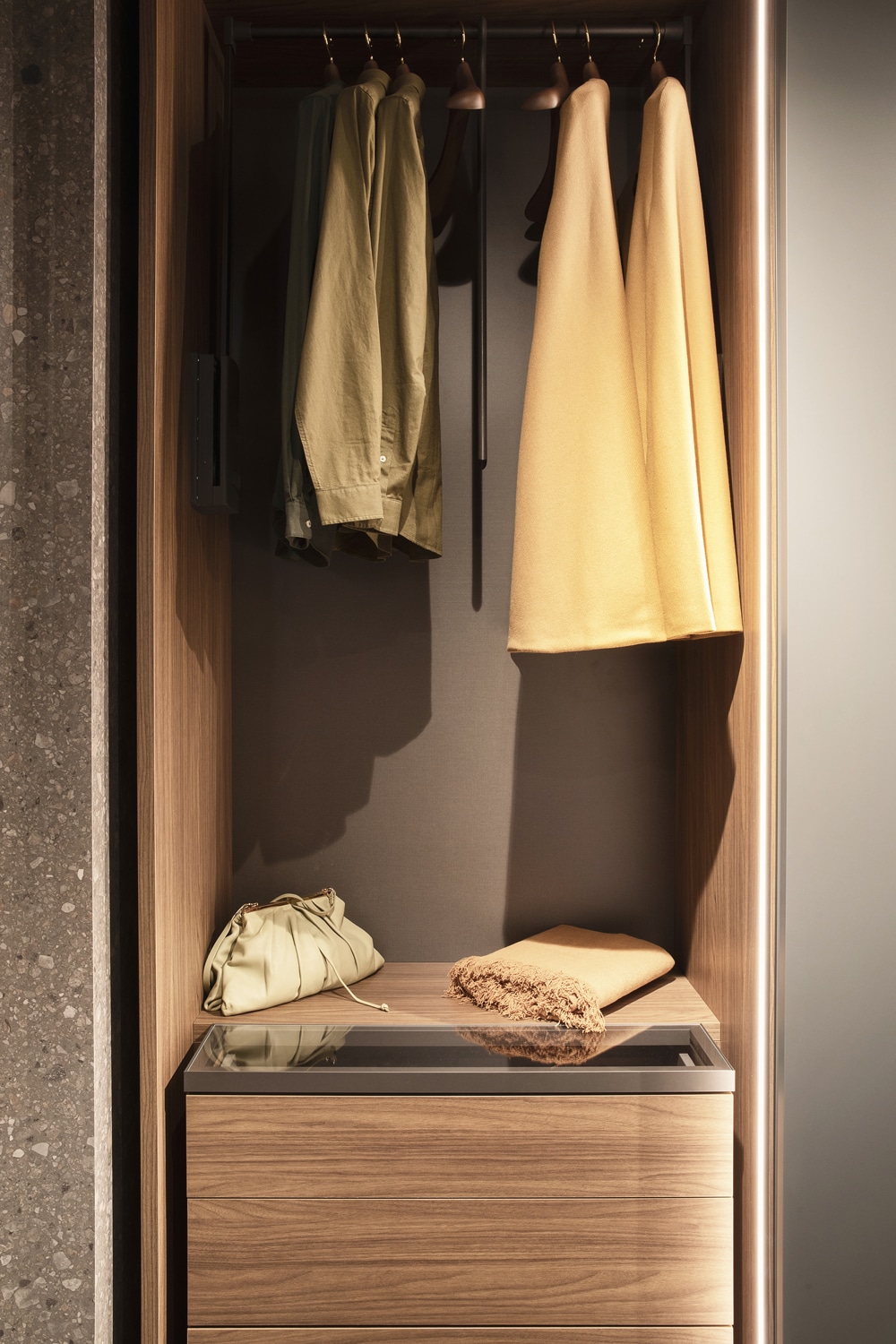 Walk-in closet module with unobtrusive LED light bar and drawer with glass top.