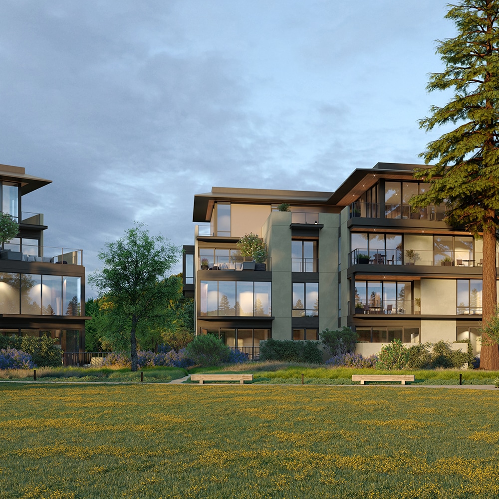 A modern apartment complex with a grassy lawn and a tree.