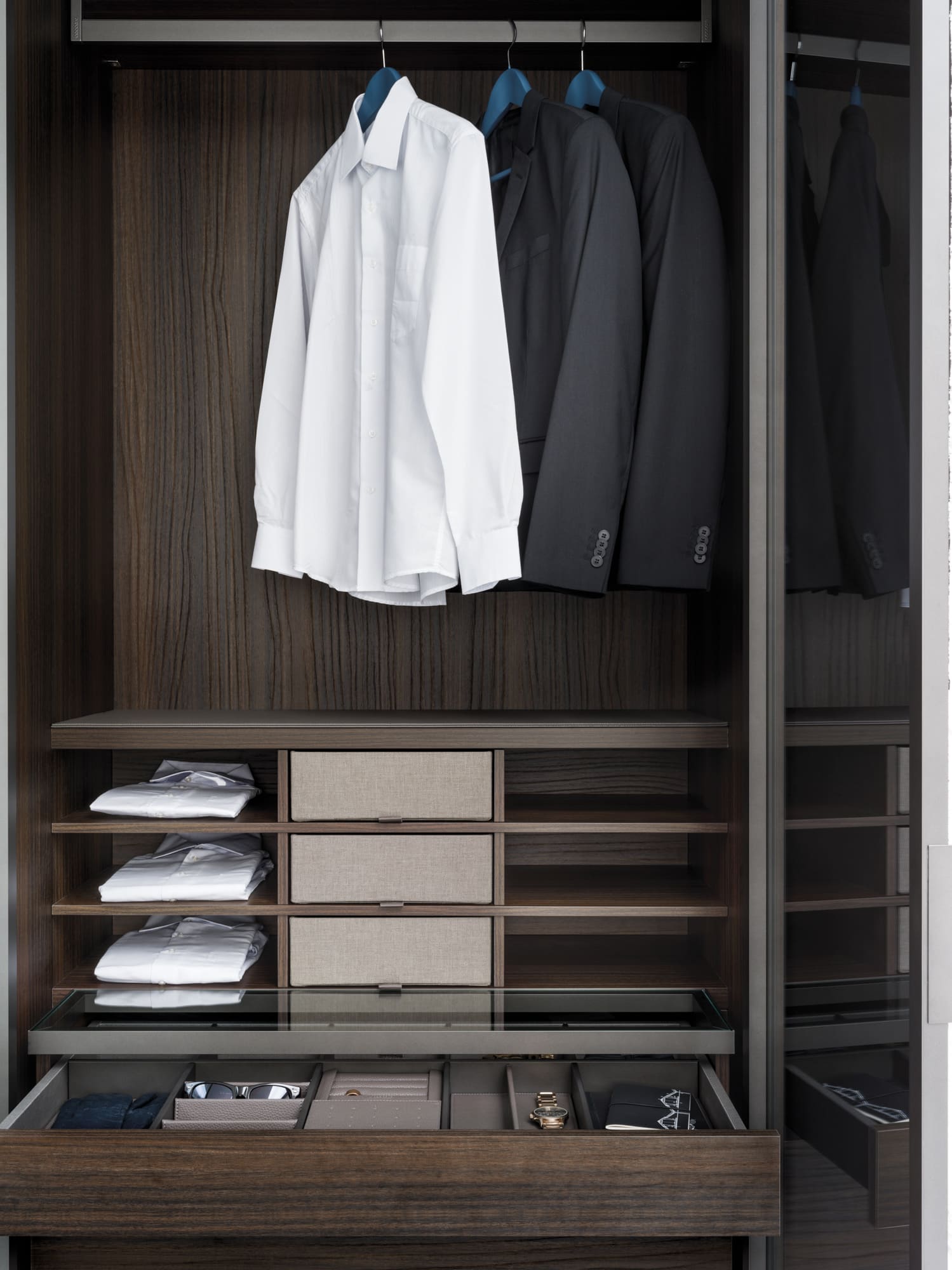 Closet interior in Easy Eucalyptus. The grid system can include 6, 8, 9 or 12 open shelves with or without extractable drawers covered in fabric, creating a play of open and closed storage spaces that is both functional and elegant.