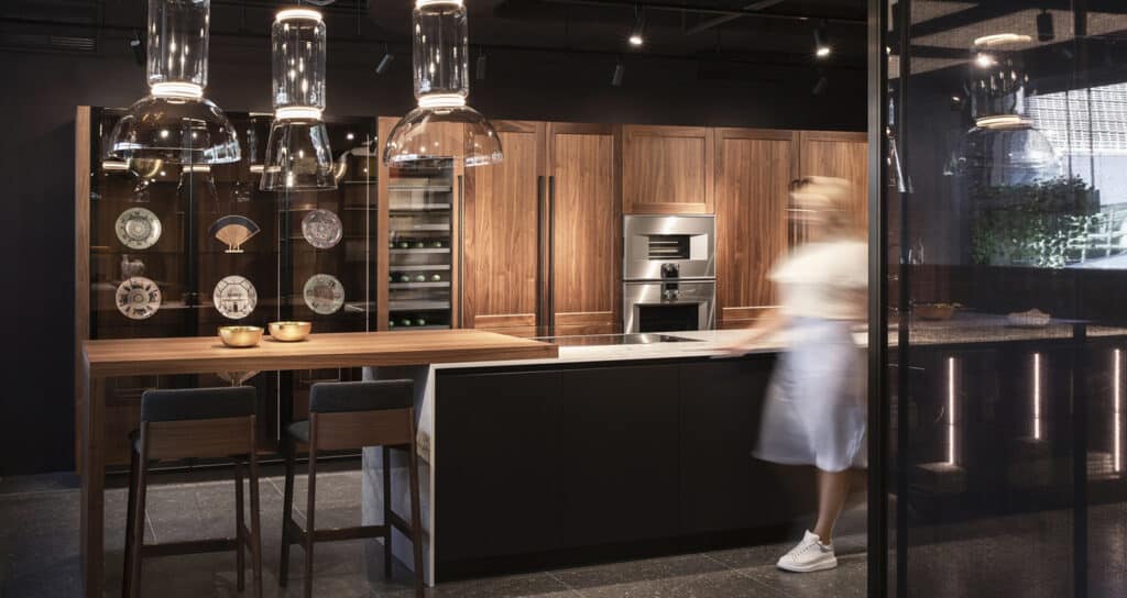 Transitional kitchen with framed cabinets in dark wood with handles and dark gray cabinets with flat doors plus framed glass cabinets.