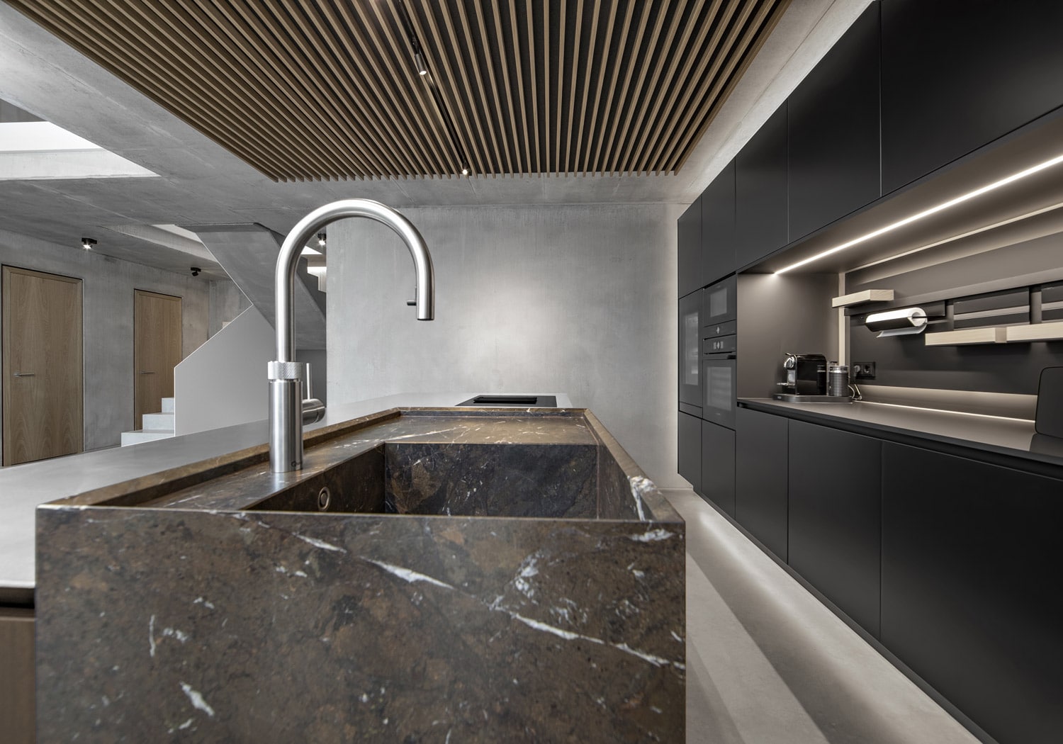 On the island, the choice of sink in Breccia Imperiale granite further highlights the project’s use of materials to define the various functional areas of the kitchen.