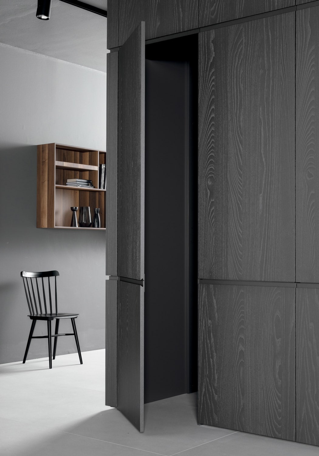 On the other side of the tall units, a door gives access to a hidden pantry. The door and the panels of this section are finished in Titanium stained Walnut to create aesthetic continuity.