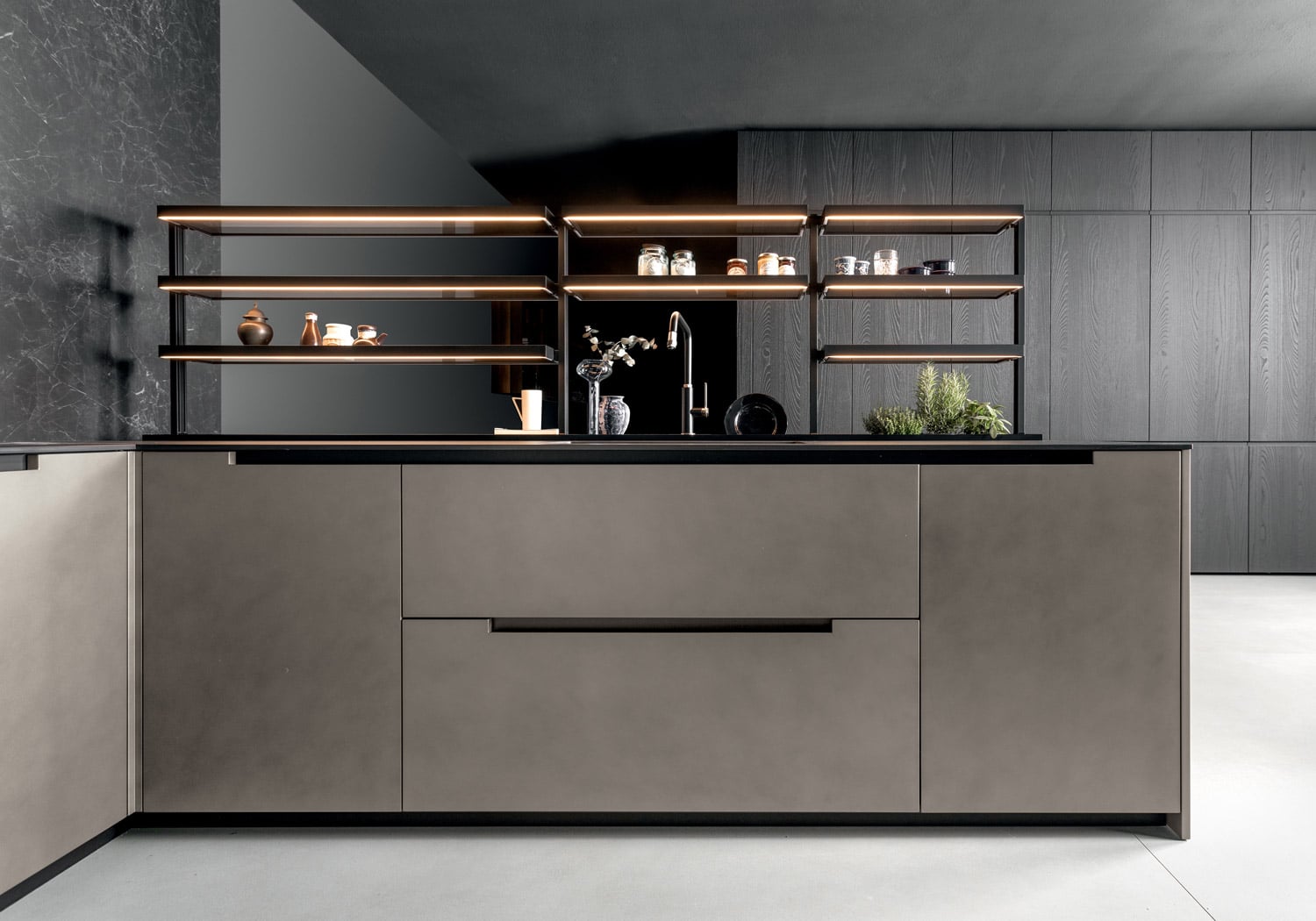 The width of the handles was customized for each cabinet to create the desired effect, with some doors showing the integrated black channel and some hiding it in part. On the back is an additional pantry wall in Smoked Walnut.