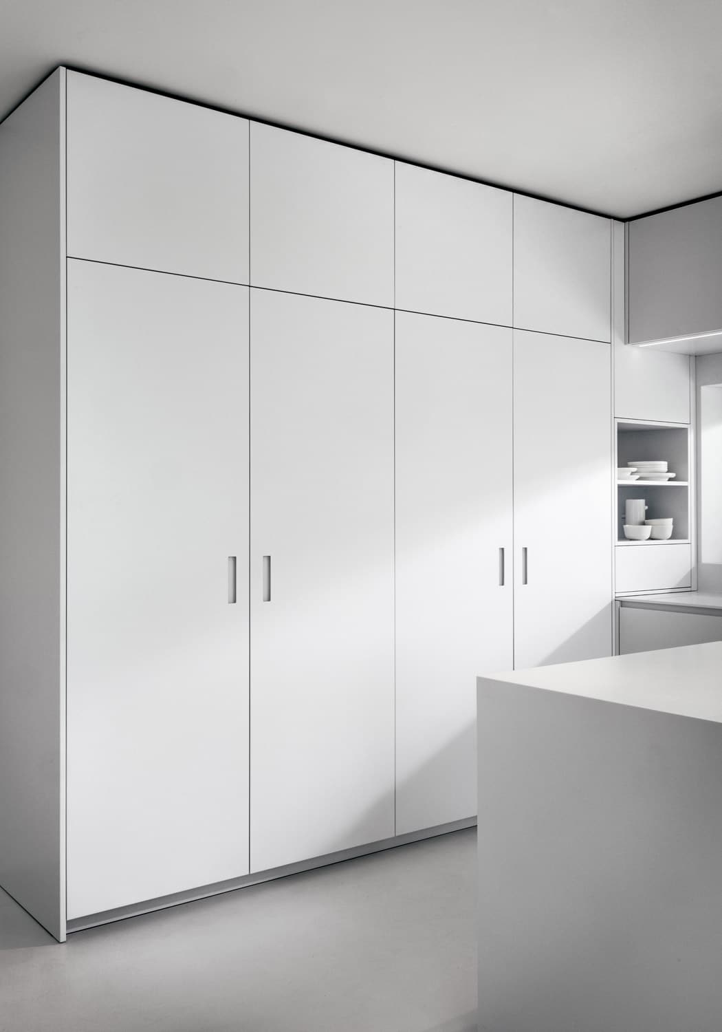 The tall cabinets are accessed through pocket doors with Oslo handles. 