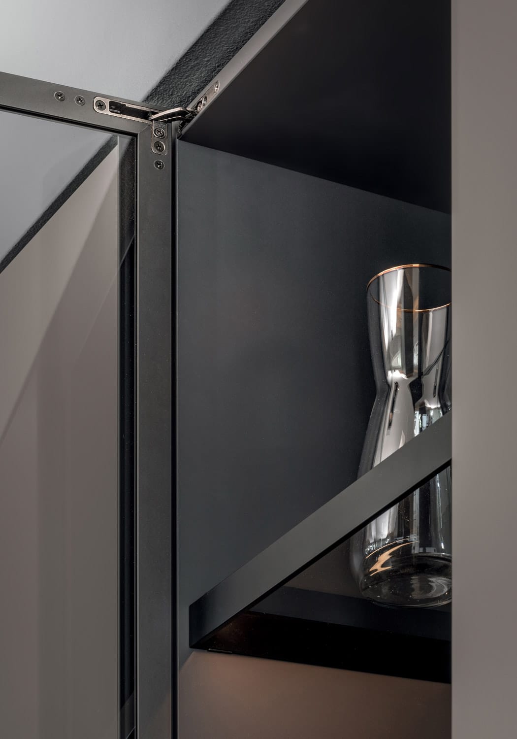 Inside, the glass shelves also feature a black lacquered aluminum profile. 