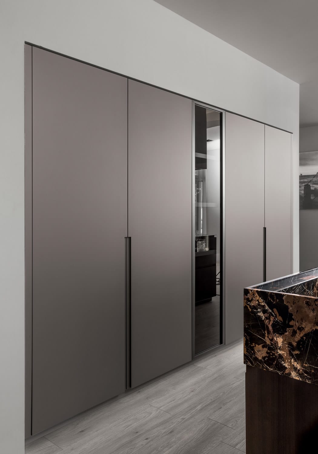 The design also includes tall units in London Grey lacquer built inside the kitchen wall. 