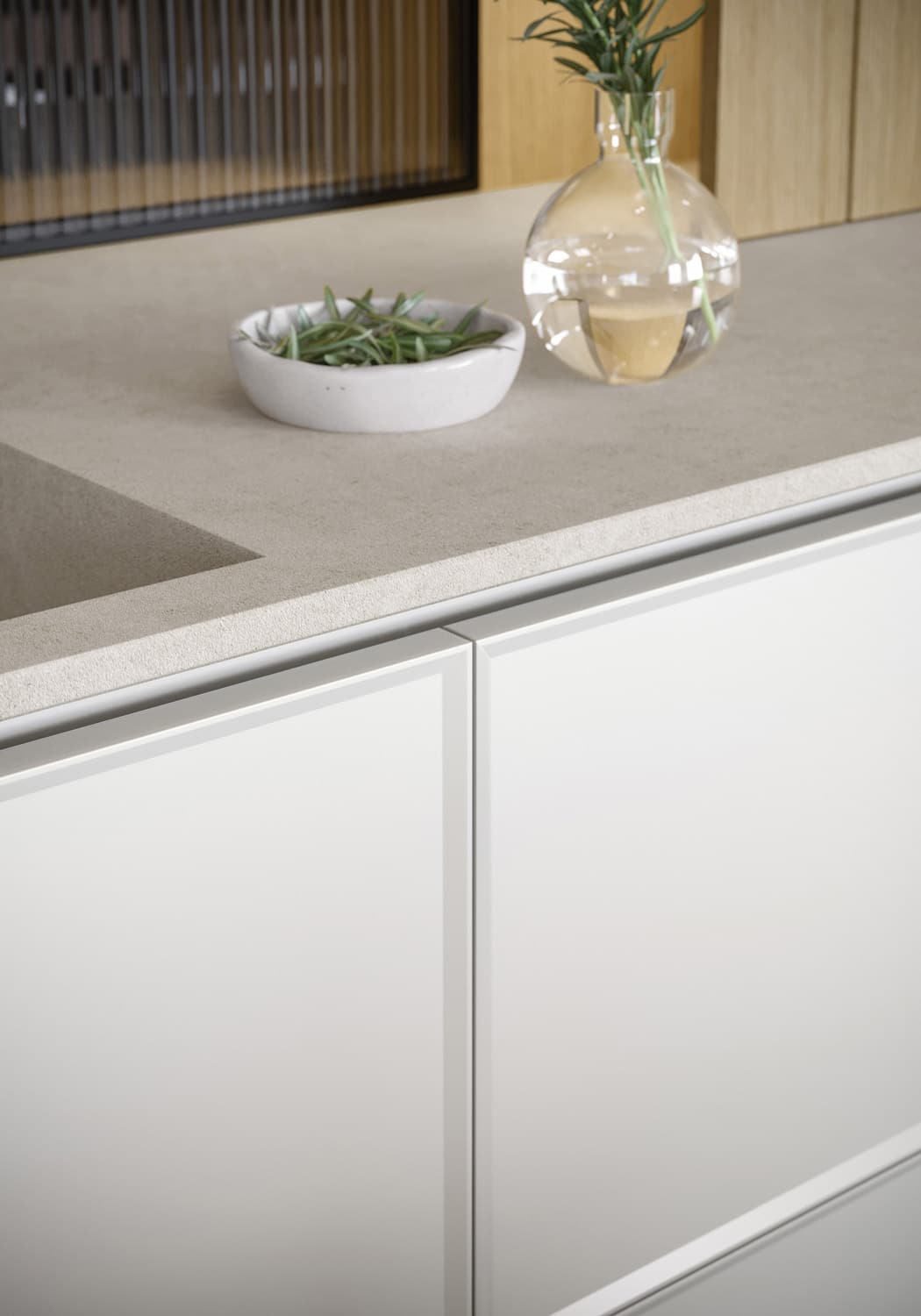 The kitchen’s base cabinets use the “Teatro” contemporary-style shaker door, which features a minimalist frame and a C-shaped integrated channel.  