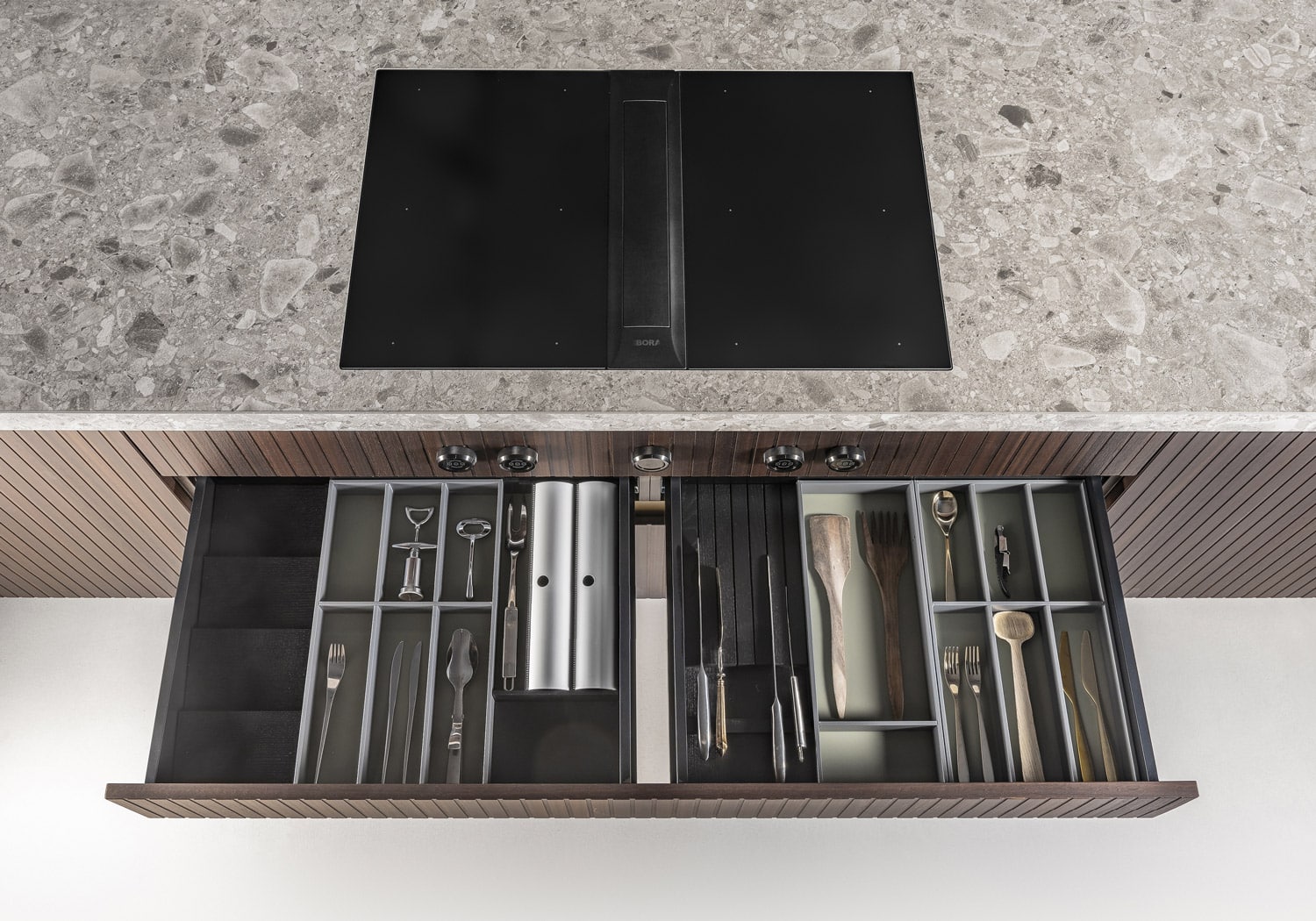 Custom inserts in aluminum organize the storage space inside drawers and deep baskets. 