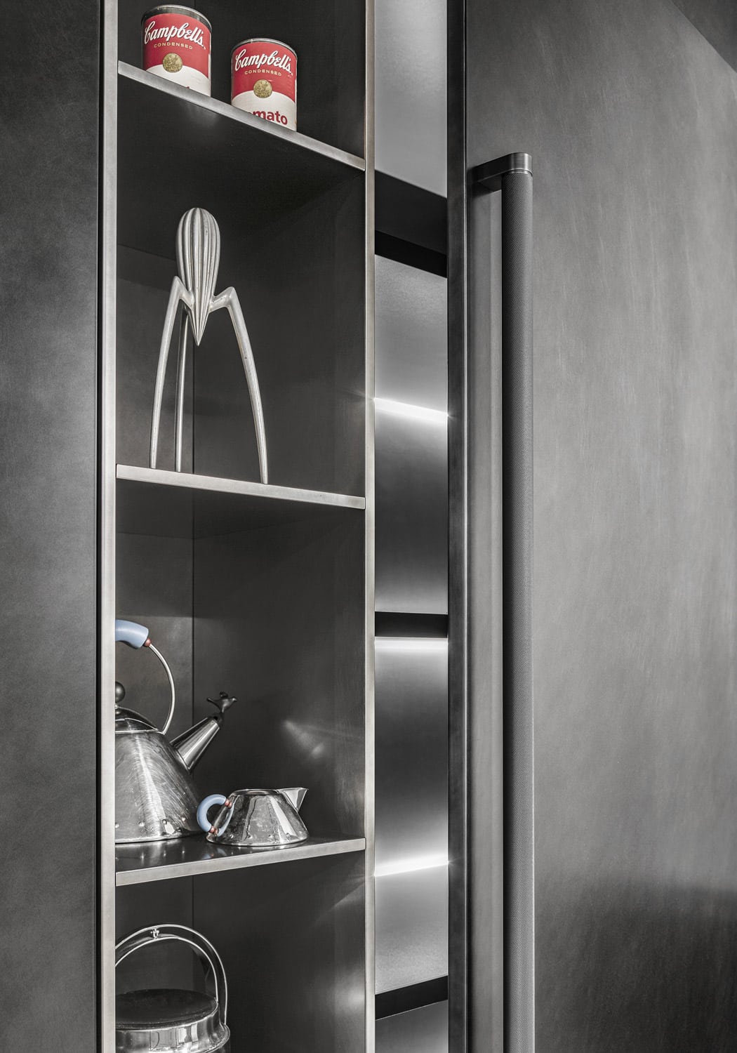 The open niches are in the same lacquered Oxidized Metal Steel finish as the rest of the tall units, creating a very contemporary look.
