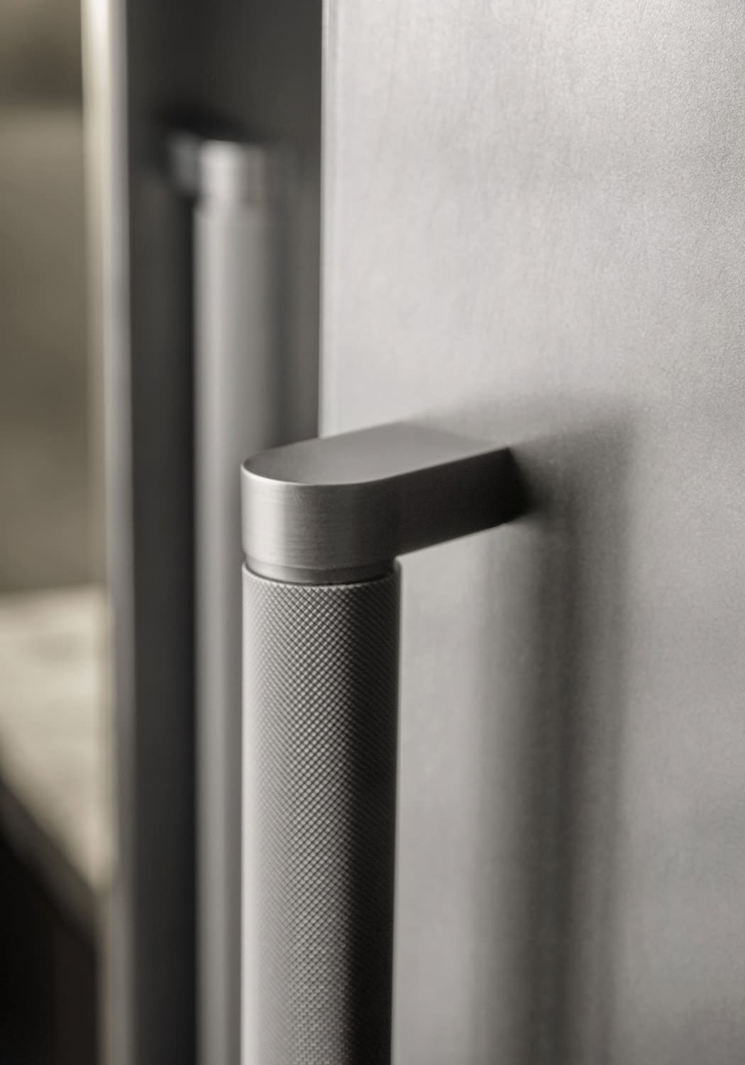 Tubular handles with engraved grip in nickel finish were used for the heavier cabinet doors.
