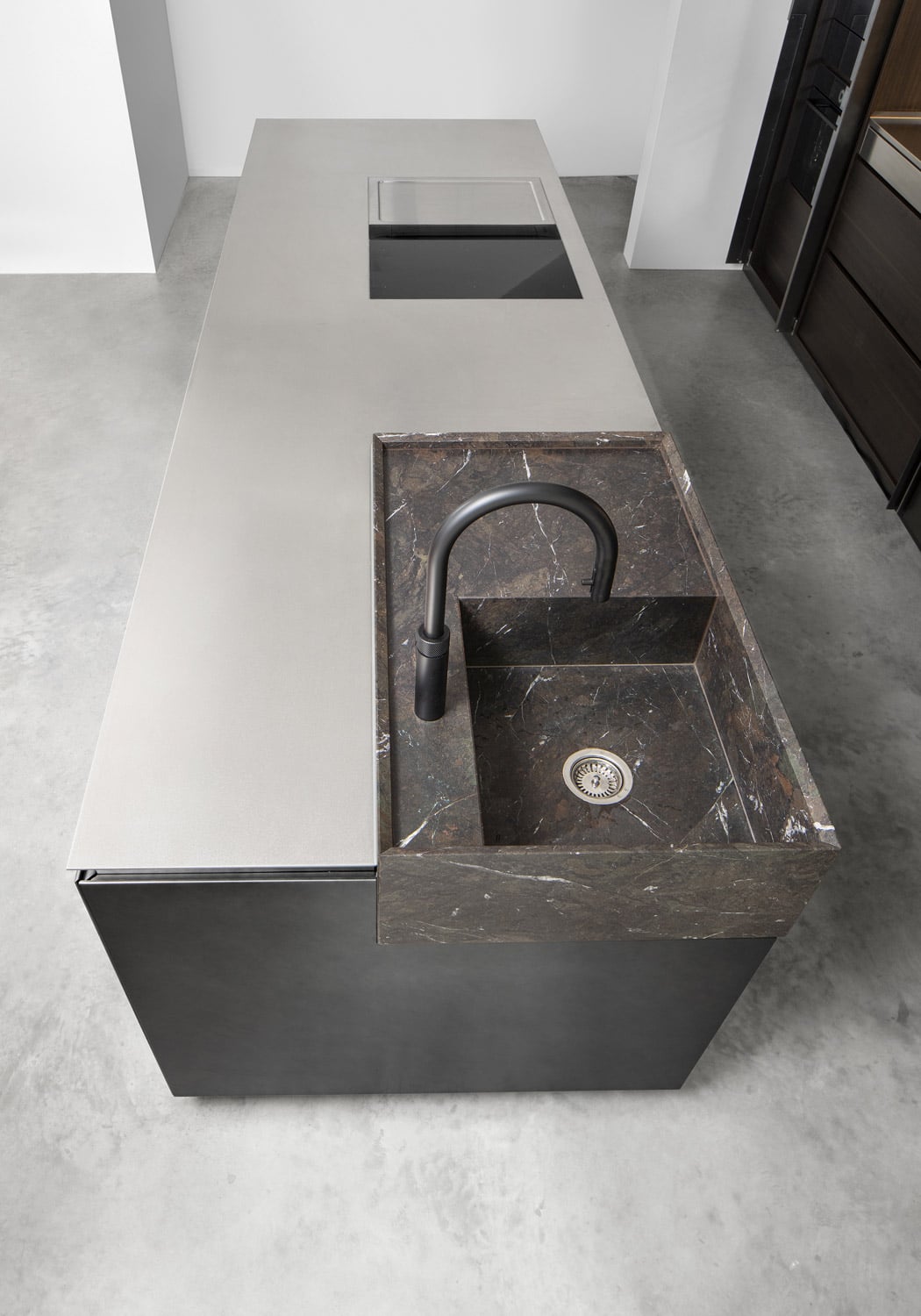 On the island, the hand-crafted single-block sink in Breccia Imperiale granite sits in contrast with the stainless steel countertop. 