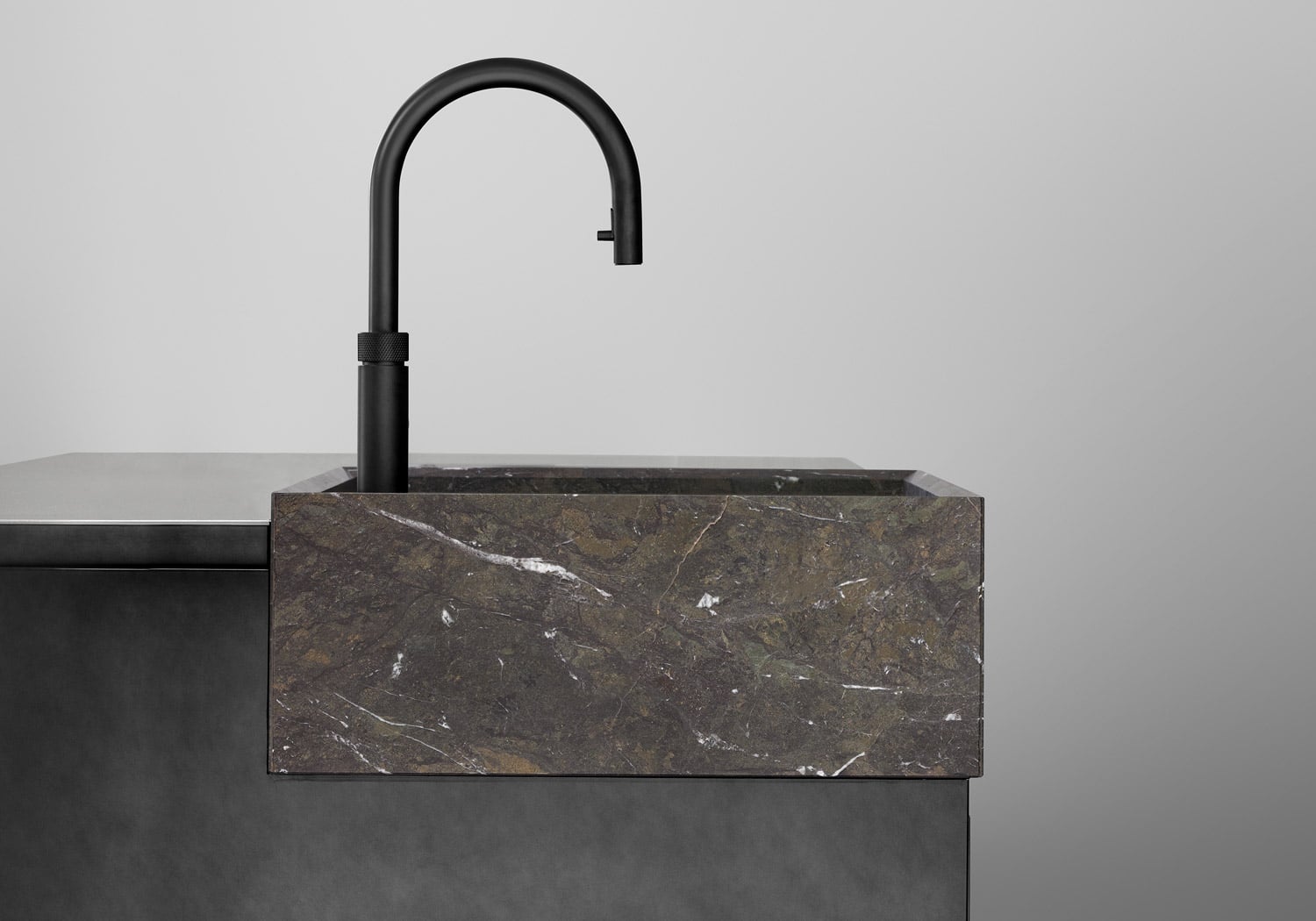 The hand-crafted sink block highlights the kitchen’s emphasis on simple volumes. 