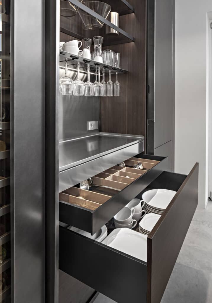 Custom-made tall kitchen cabinet with worktop, glass shelves with aluminum profiles, stemware rack, drawers and deep storage baskets.