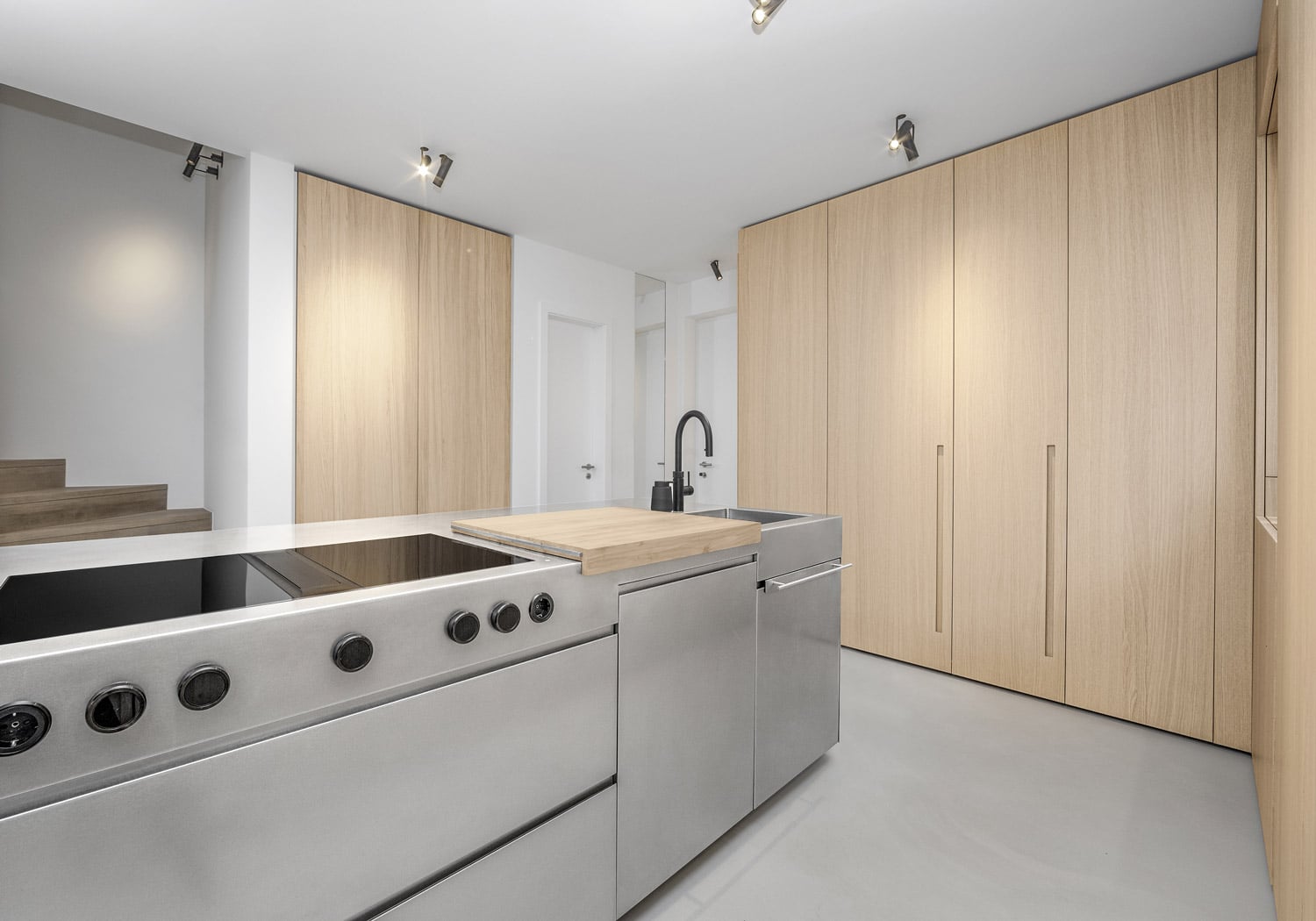 The design of the island mirrors large professional kitchens, in both aesthetics and functionality. The light Natural Oak softens the look of the stainless steel.