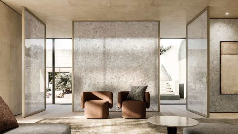 Modern living room with glass partition walls and plush seating.