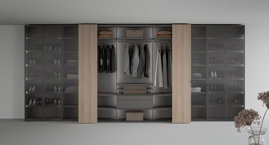 Luxury closet in grey lacquer, smoked glass, and light oak wood with bifolding doors taking up minimal space