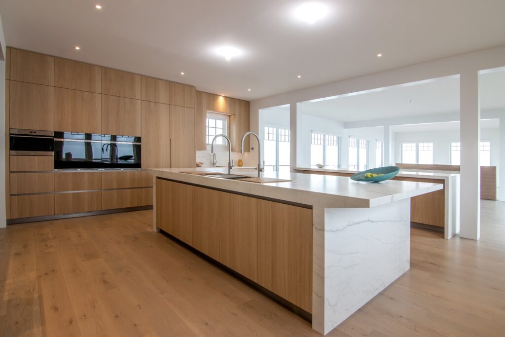 Custom designed luxury kitchen island with cabinets in light oak, sculptural countertop and sides in Neolith Mont Blanc