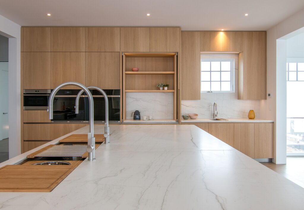 Luxury bespoke kitchen design with large island and wall cabinet with pocket doors